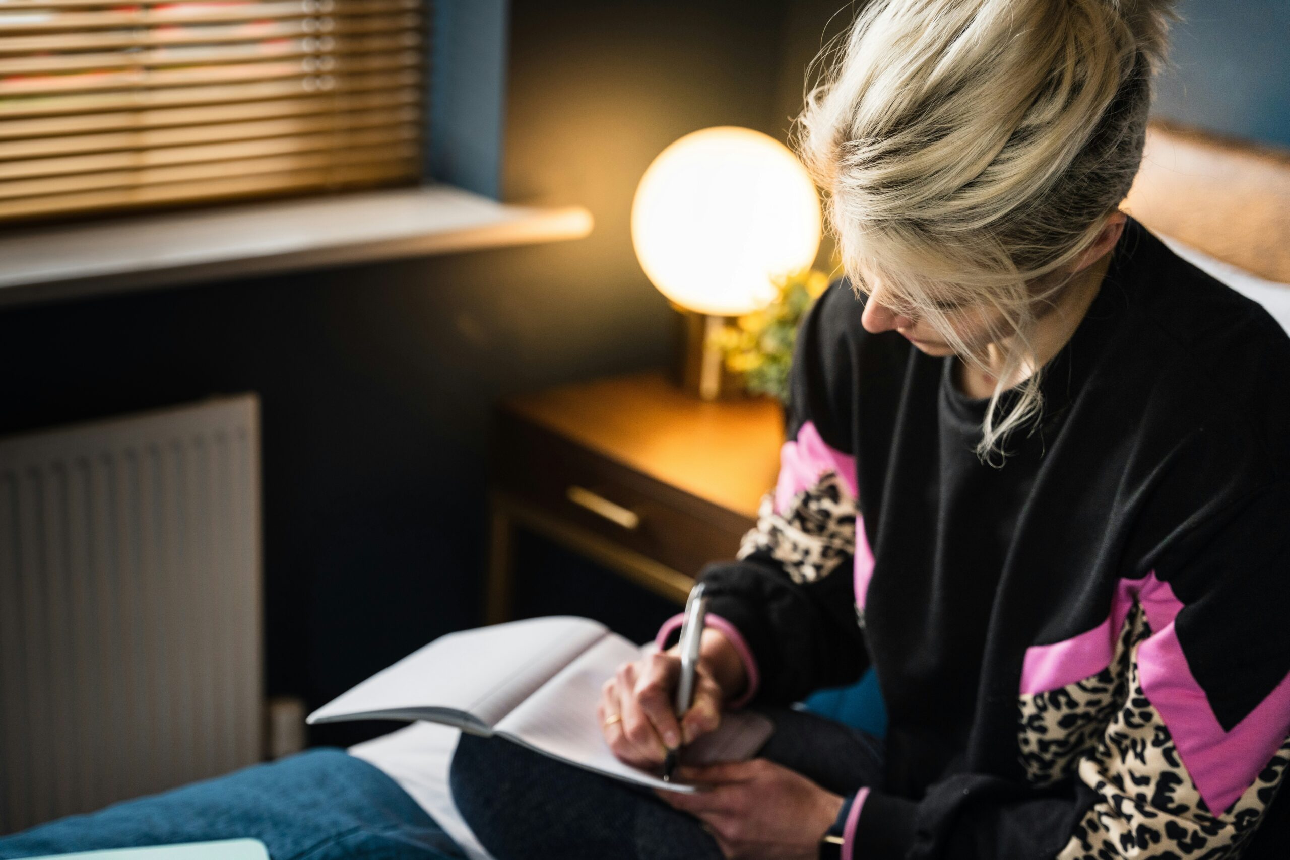 Resilienz stärken — Frau reflektiert mit Notizbuch